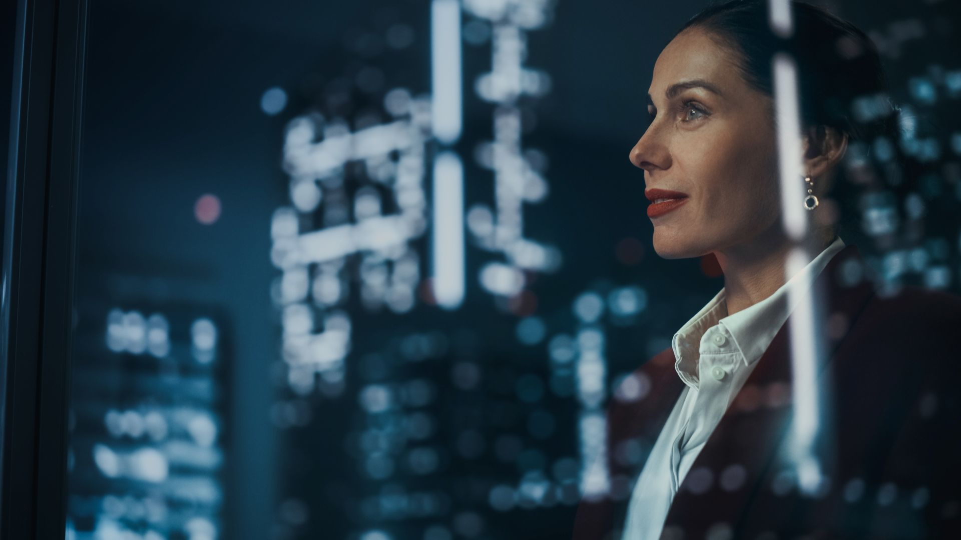 Woman looking out of a window at night